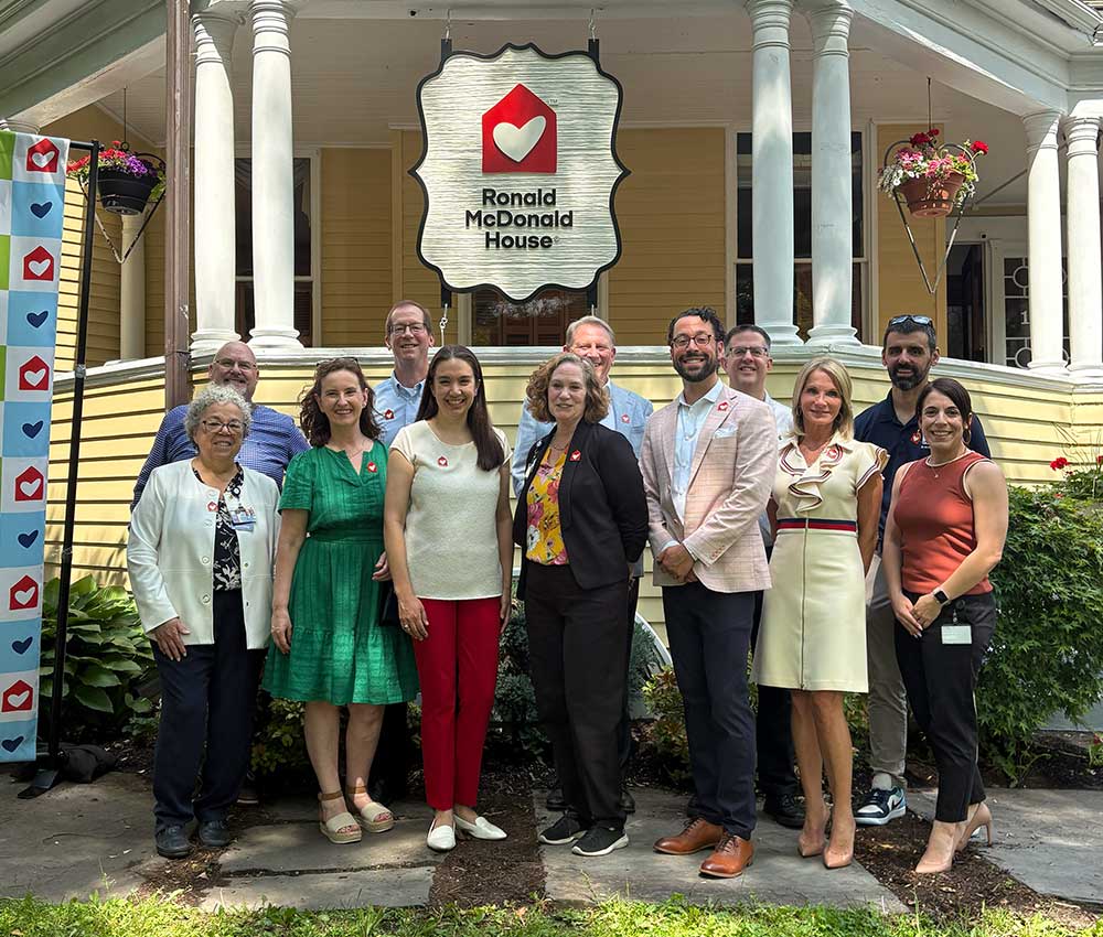 Ronald McDonald House Albany board members posing for a photo in front of the new porch sign