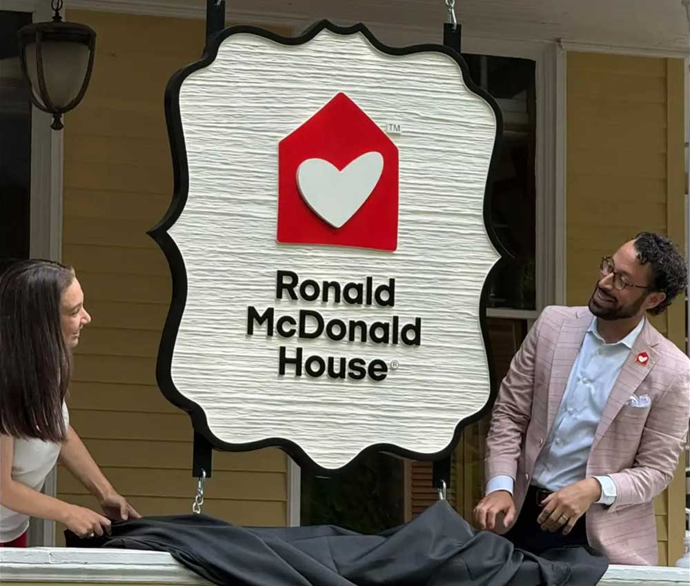 CEO Kimmy Venter and Board President Daniel Miller unveiling new front porch sign at Ronald McDonald House Albany