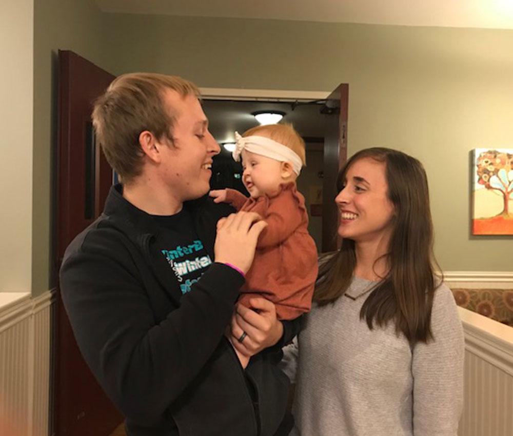 Mom and dad smile at their young baby in the kitchen at the Ronald McDonald House