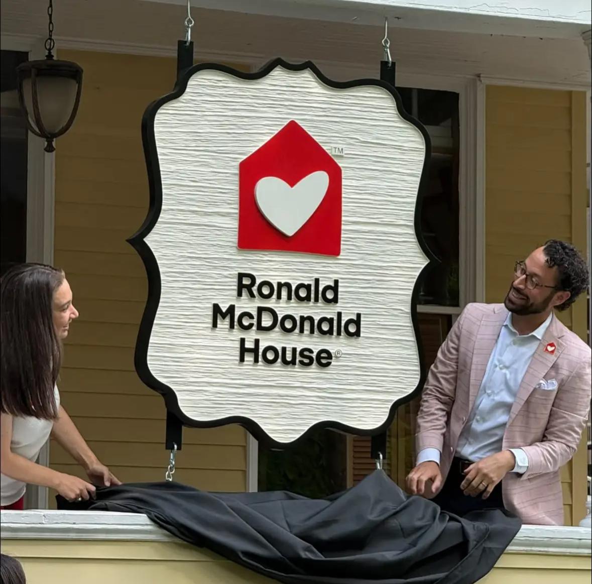 Ronald McDonald House Albany CEO Kimmy Venter and Board President Daniel Miller unveiling the new front porch sign