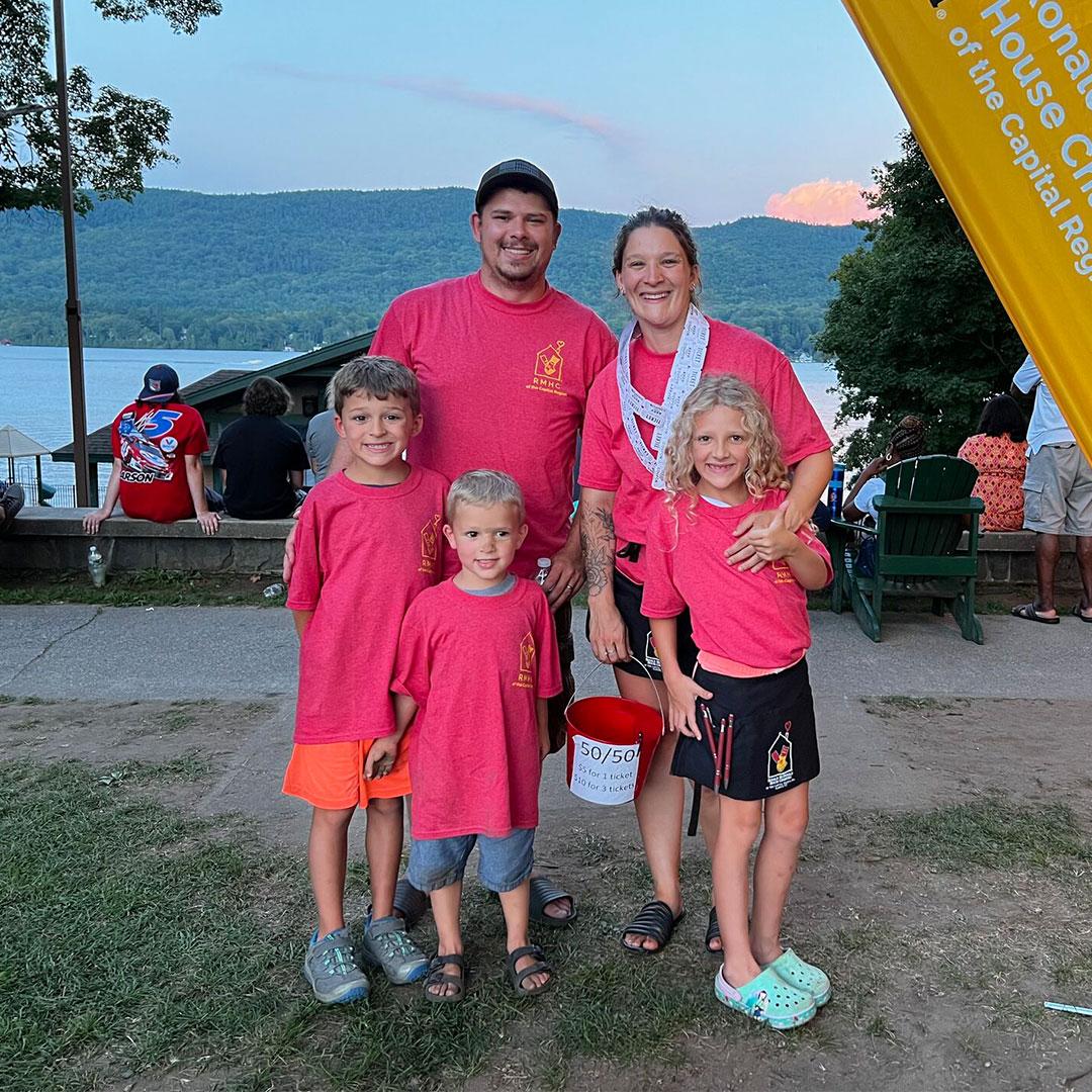 A family of five poses at an event where they are selling raffle tickets for Ronald McDonald House Albany